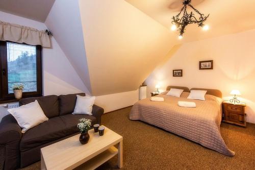 a living room with a bed and a couch at Willa Litworówka III Wellness&SPA in Poronin