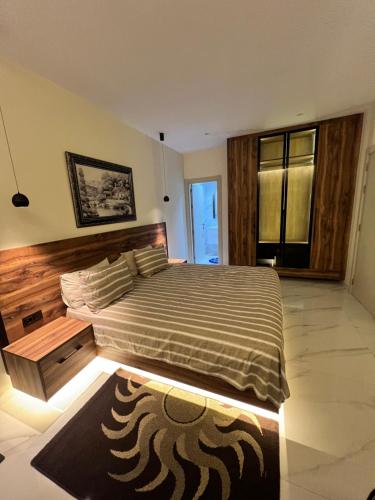 a bedroom with a large bed with a wooden headboard at maisoncarnot in El Biar