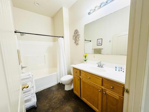 ein Badezimmer mit Waschbecken, Toilette und Spiegel in der Unterkunft Chateau 4 in Hammond