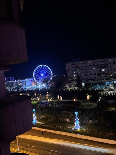 a ferris wheel in a city at night at Apartament ultracentral in Craiova