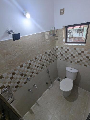 a bathroom with a toilet and a shower with a window at Sankeerthanam - Lounge in serenity in Cochin