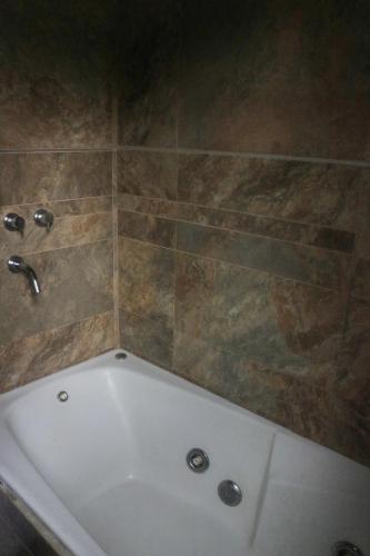 a white bath tub in a bathroom with a tile wall at Quiya ná in Cortaderas