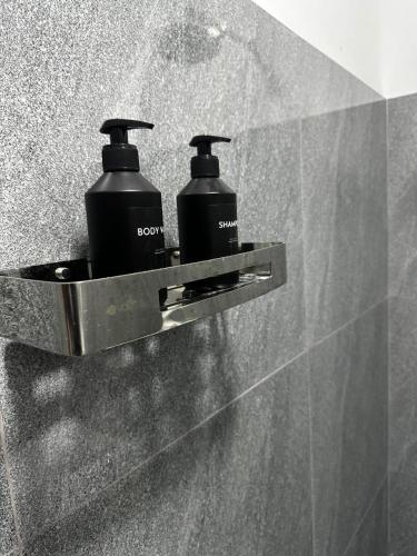 two soap bottles on a holder on a wall at Seven Crest Hotel Anuradhapura in Anuradhapura