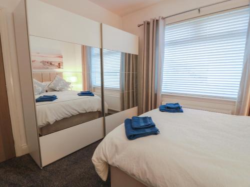 a bedroom with two beds and a large mirror at Marchdyke Farm Cottage in Lockerbie