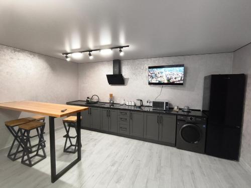 Котедж у Русина في Pilipets: مطبخ مع طاولة وتلفزيون على الحائط