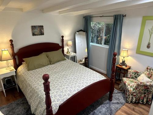 a bedroom with a bed and a chair and a window at Sal's Beach Cottage Retreat in Fort Bragg
