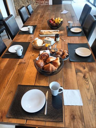 Pierrefitte-en-AugeにあるHameau Fleuriの長い木製テーブル(皿、食べ物付)