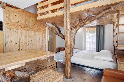 a room with a bed and a tree in it at Agriturismo Vento Alpino in Coredo