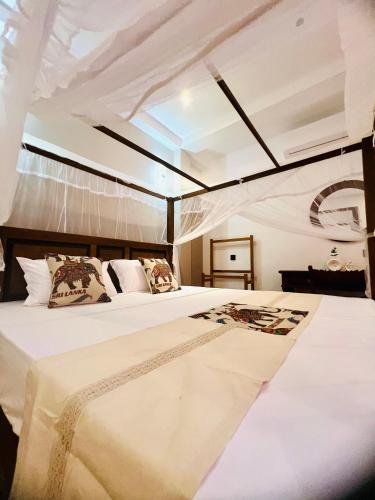 a bedroom with two beds and a ceiling at VOGEL NEST in Midigama East