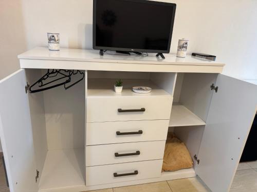 una scrivania bianca con una televisione sopra di Suíte Park e Mar quarto 2 a Penha