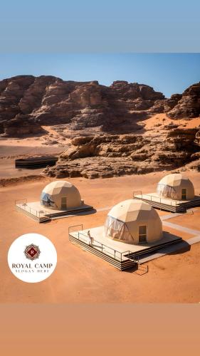 three tents in a desert with rocks in the background at Royal camp in Wadi Rum