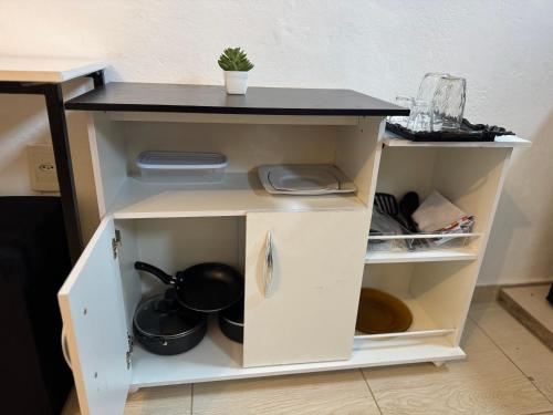 un mobile bianco con un piano di lavoro nero di Suíte Park e Mar quarto 2 a Penha