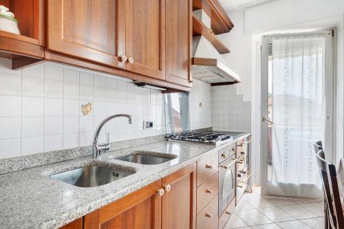 a kitchen with wooden cabinets and a sink at Agriturismo Vento Alpino in Coredo