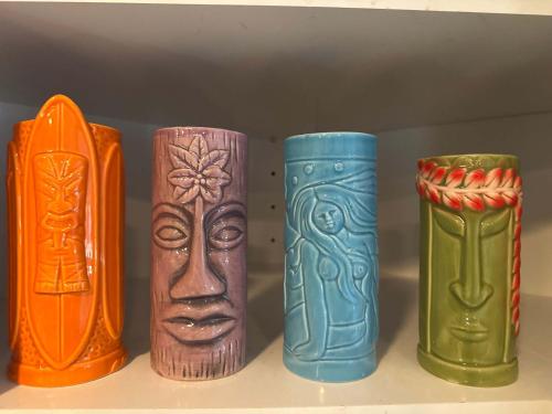 Cape Coral Beach House في كيب كورال: أربعة مزهريات ملونة مختلفة موجودة على رف