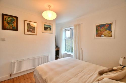 斯内蒂瑟姆Carrstone Cottage, Snettisham的一间卧室，配有一张大床和一扇窗户。