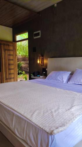 a bedroom with a large bed with a white bedspread at Dothalu Villa in Ahangama