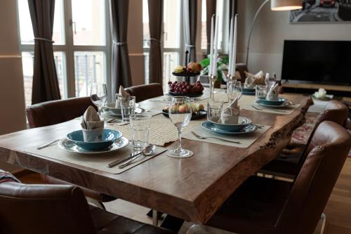 a long wooden table with plates and wine glasses at Loft - Zur alten Schule in Essingen in Essingen