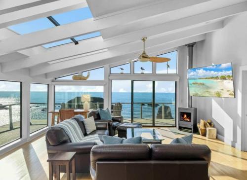 a living room with a couch and a fireplace at Seaside Elegance Oceanfront Escape with 3 Suites in Carmet