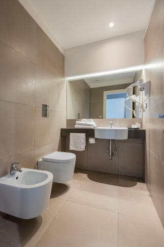a bathroom with a sink and a toilet and a mirror at Hotel Europa in Naples