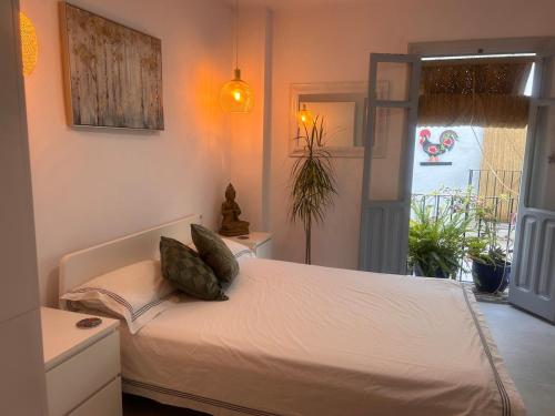 a bedroom with a white bed with pillows on it at Fabulous 2 bed-townhouse with large rooftop! in Estepona