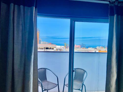 two chairs sitting in front of a window at Hotel Khantati SPA in Iquique