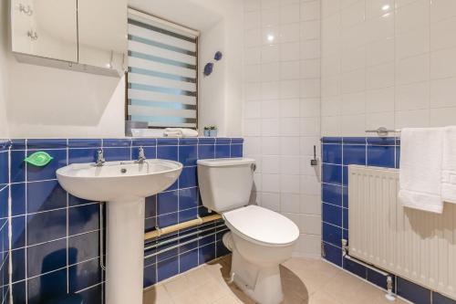 een blauw betegelde badkamer met een toilet en een wastafel bij 3 Bed in Torpoint oc-l32511 in Downderry