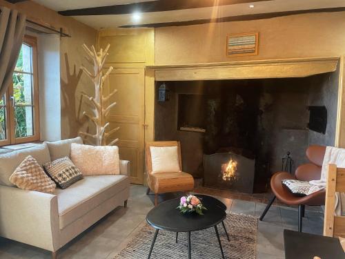 a living room with a couch and a fireplace at Éco-domaine Gîtes et Spa - Mer, Nature & Confort - Côte d'Opale in Wierre-Effroy