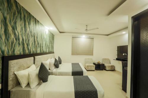 una habitación de hotel con dos camas y una mesa en Precesion Palace Suites Near Delhi Airport, en Nueva Delhi