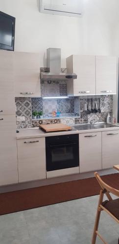 a kitchen with white cabinets and a stove top oven at casa di Francesco e Azzurra in Torre del Greco