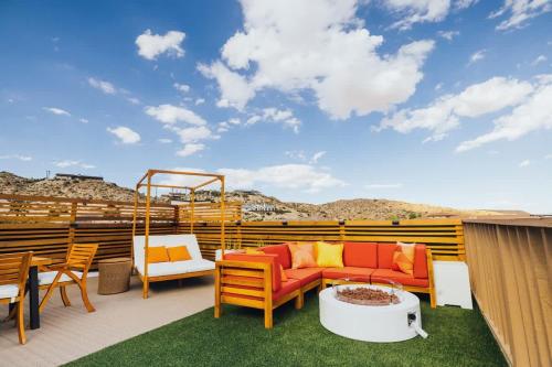 a patio with a couch and chairs and a table at Mandarin Escape By The Cohost Company in Yucca Valley