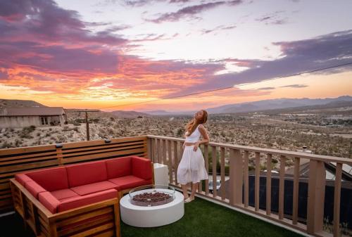 a woman standing on a balcony looking at the sunset at Mandarin Escape By The Cohost Company in Yucca Valley