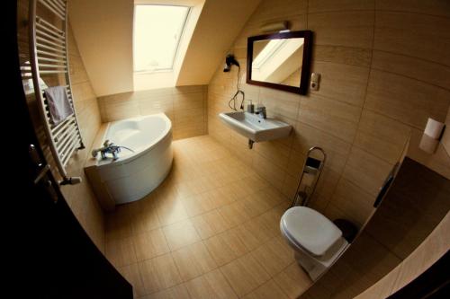 a bathroom with a sink and a tub and a toilet at Dwa Bratanki in Rzeszów