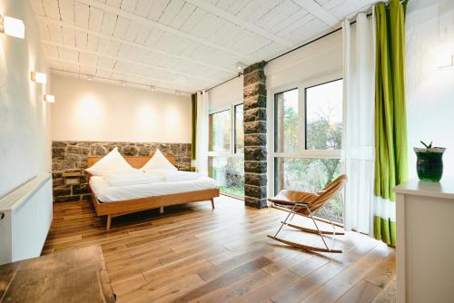 un dormitorio con una cama y una silla en Basalt-Loft, en Kottenheim