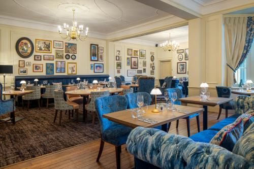 a restaurant with tables and couches and chairs at The Warwick Arms Hotel - The Coaching Inn Group in Warwick