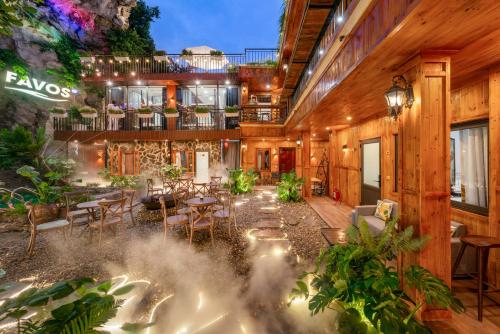 Vũ LâmFavos Ninh Binh Hotel & Villas的带有露台和桌椅的建筑