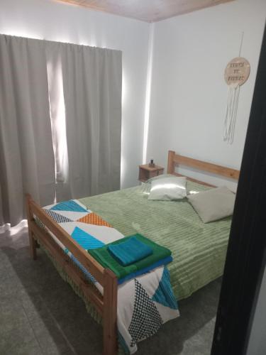 a bedroom with a bed with a green comforter at Cabañas Emilia in La Adela