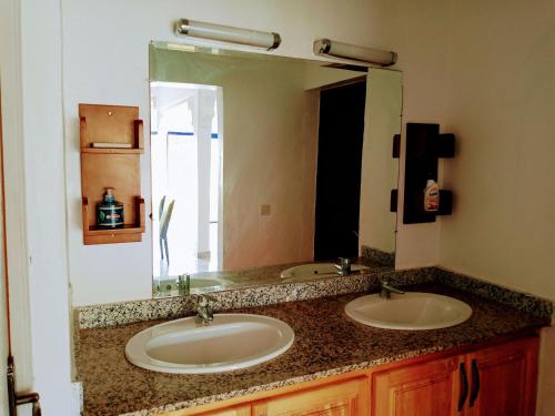 a bathroom with two sinks and a large mirror at Riad Elbahi in Marrakech