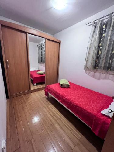 a bedroom with a red bed and a mirror at Adrialana in Porozina