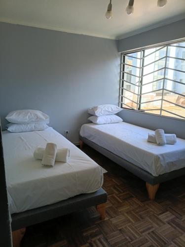 zwei Betten in einem Zimmer mit Fenster in der Unterkunft Casa Quinta Vergara in Viña del Mar