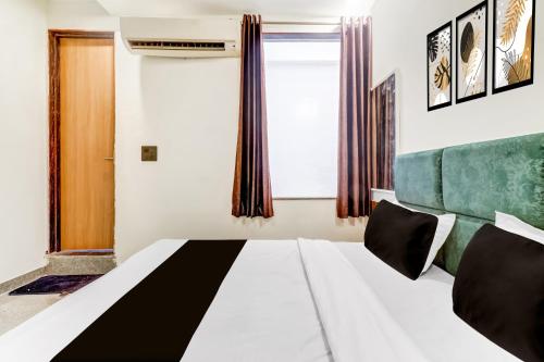 Un dormitorio con una cama y una ventana en Hotel O Riwaz Inn, en Gwalior