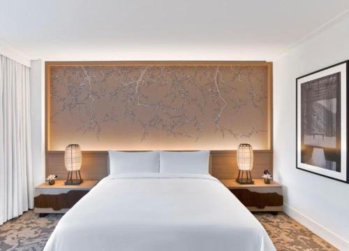 Un dormitorio con una gran cama blanca y dos lámparas. en WZORCOWNIA DELUXE Apartments with VIEW, en Włocławek