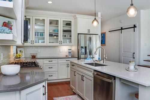 una cucina con armadietti bianchi ed elettrodomestici in acciaio inossidabile di Gone Coastal by Pristine Properties Vacation Rentals a Mexico Beach