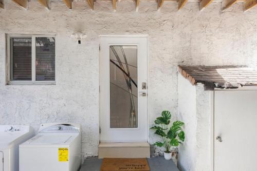 una casa blanca con lavadora y ventana en Cozy By The Blue, en Miami