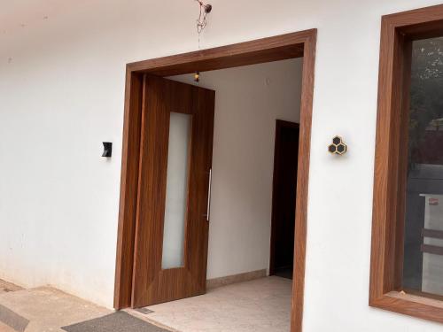 uma porta de madeira numa parede branca em The Dayal Hotels em Ayodhya