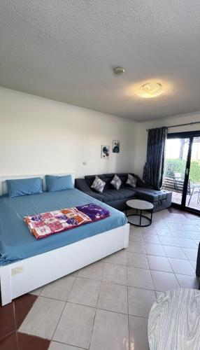 a bedroom with a bed and a couch at la hacienda studio in Ras Matarma