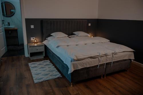 a bedroom with a large bed with white sheets and pillows at Pensiunea CityView in Câmpulung Moldovenesc