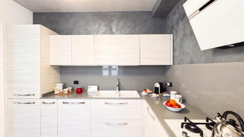 a kitchen with white cabinets and a sink at Lady Teresa 2-0 by Ca-Sa Check in Chioggia