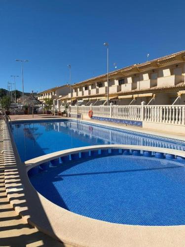 a large swimming pool in front of a building at Apartalux Playa Paraíso in La Manga del Mar Menor