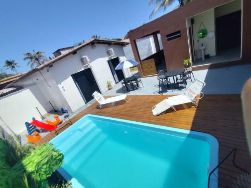 a backyard with a swimming pool and a house at Pousada Esspaço Vista Mar in Itanhaém