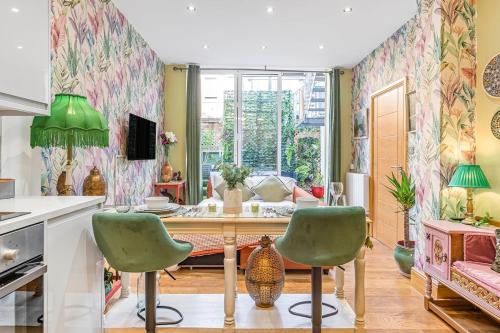 a kitchen with a table and two green chairs at Charming 2 Bed and 3 Bath Apartment in Covent Garden ZONE 1 in London